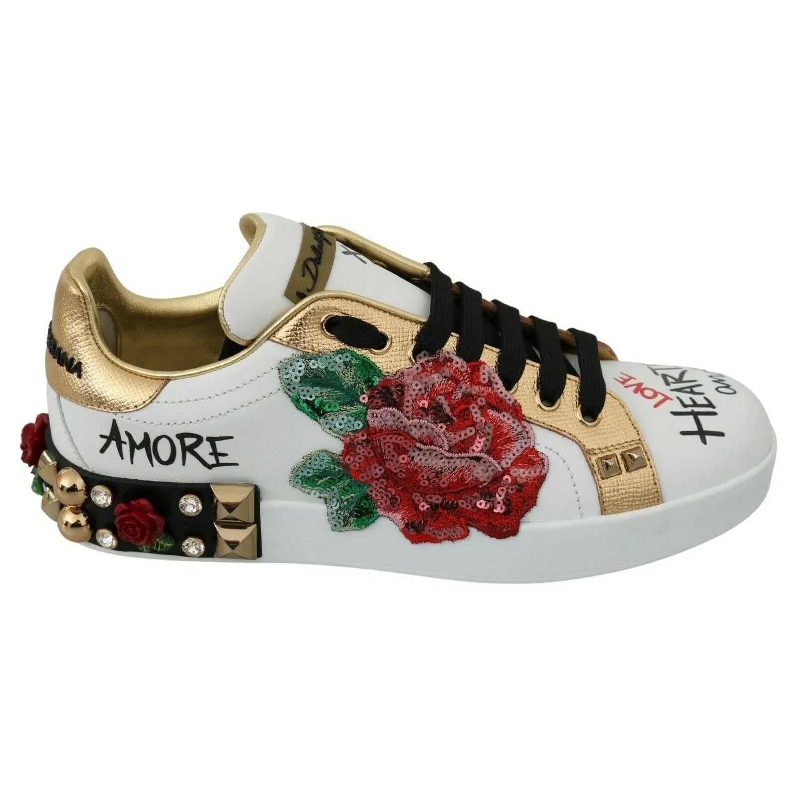 White designer sneaker with gold accents, red rose embroidery, studs, and sequin embellishments
