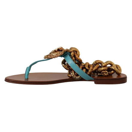 Turquoise leather thong sandal with gold metallic braided chain detail on flat brown sole
