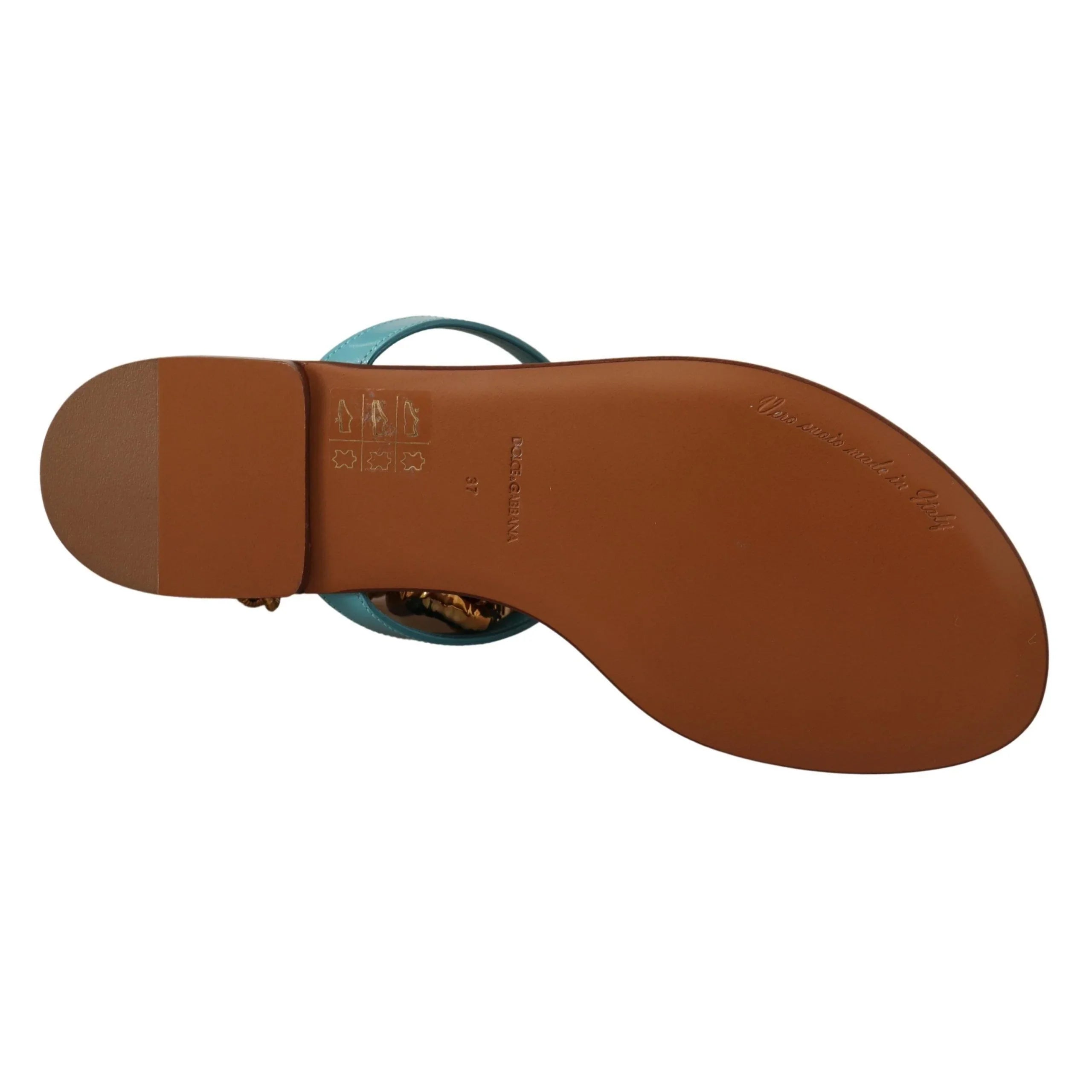 Bottom view of a turquoise sandal with leather sole and embossed brand text