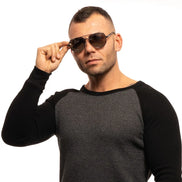 Man in aviator sunglasses and two-tone sweater posing against white background