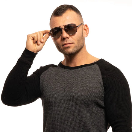 Man in aviator sunglasses and two-tone sweater posing against white background