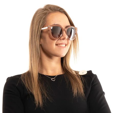 Woman in stylish round sunglasses and black top with heart necklace, isolated on white