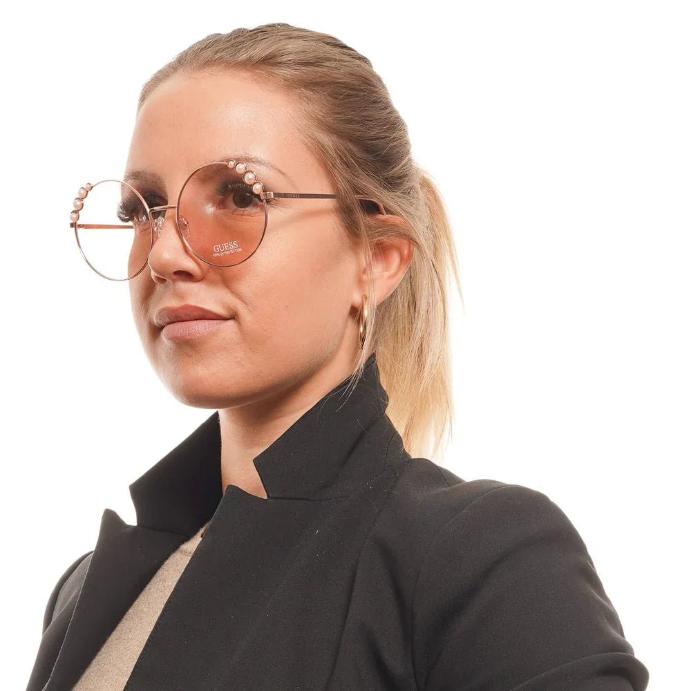 Woman wearing oversized round Guess sunglasses with pearl accents and a black blazer