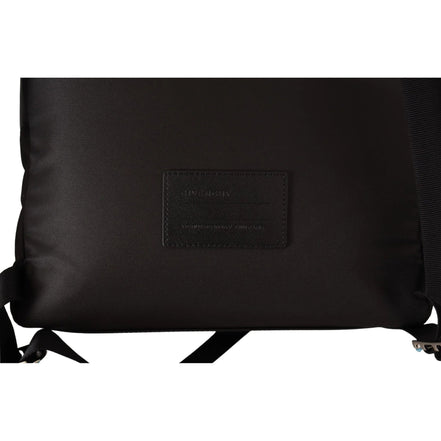 Close-up of black designer backpack with leather patch and adjustable straps